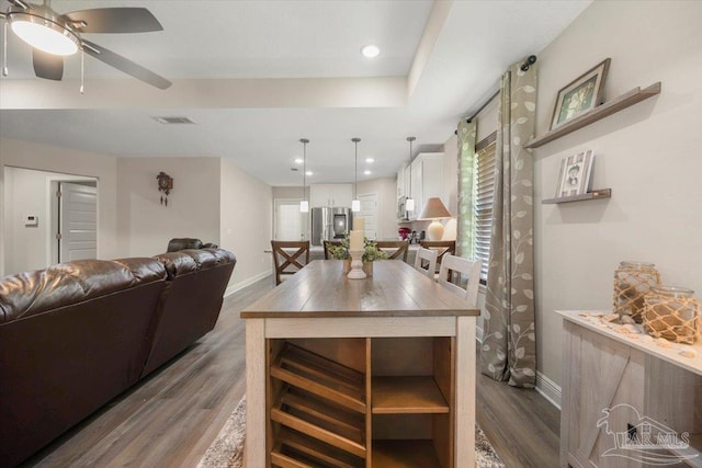 kitchen with pendant lighting, dark wood-type flooring, white cabinets, and appliances with stainless steel finishes