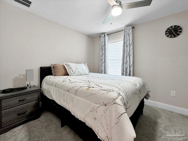 carpeted bedroom featuring ceiling fan and a textured ceiling