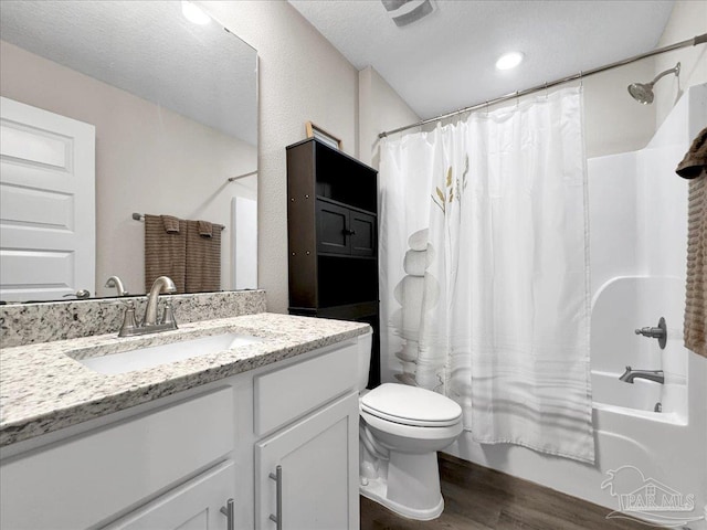 full bathroom featuring shower / tub combo with curtain, toilet, wood-type flooring, a textured ceiling, and vanity