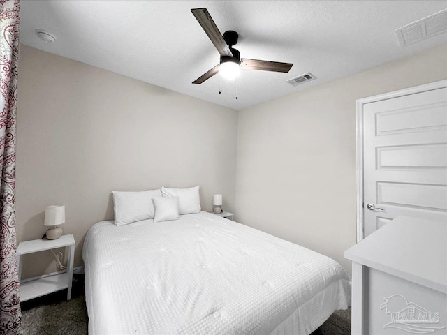 carpeted bedroom with a textured ceiling and ceiling fan