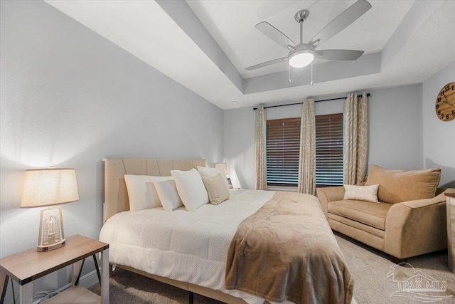 bedroom featuring ceiling fan and a raised ceiling