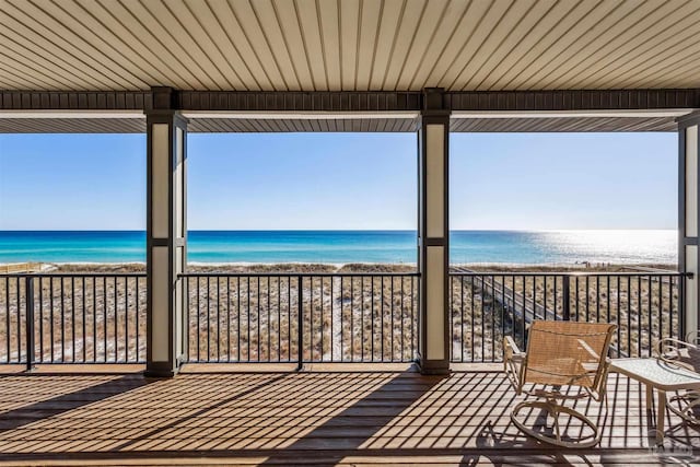 wooden deck featuring a view of the beach and a water view