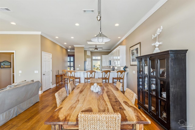 dining space with hardwood / wood-style floors, ceiling fan, and ornamental molding