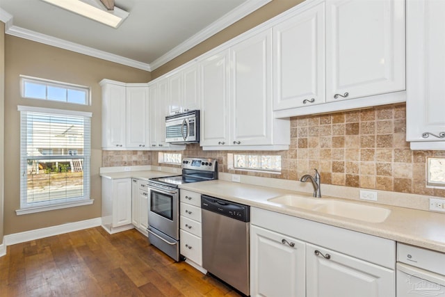 kitchen featuring white cabinetry, sink, stainless steel appliances, dark hardwood / wood-style flooring, and crown molding