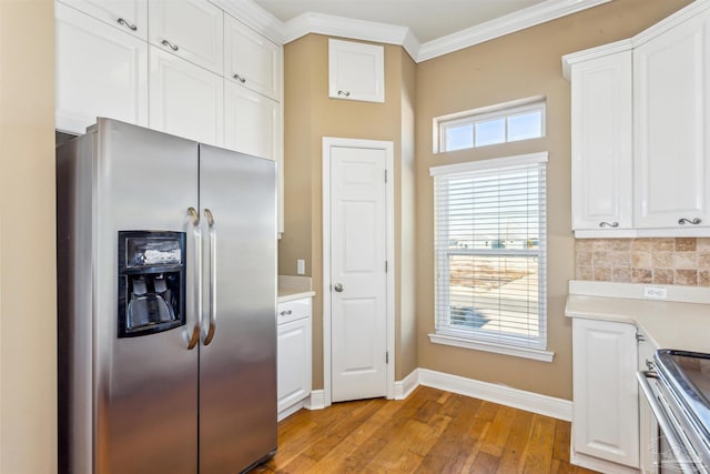 kitchen with light wood-type flooring, backsplash, ornamental molding, stainless steel appliances, and white cabinetry