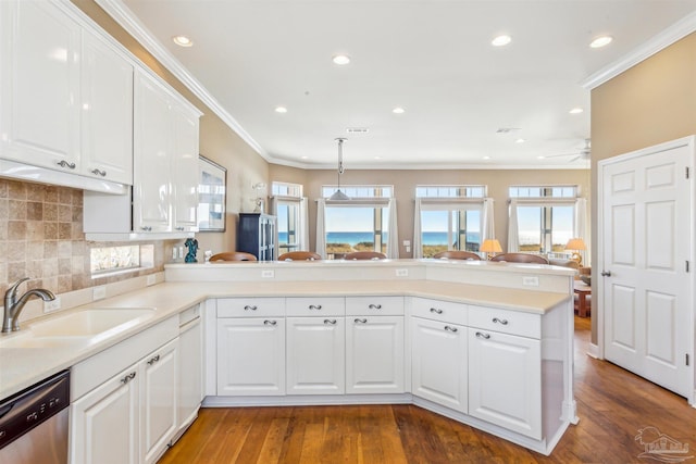 kitchen with kitchen peninsula, white cabinets, stainless steel dishwasher, and sink