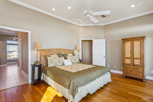 bedroom with hardwood / wood-style floors, ceiling fan, and ornamental molding