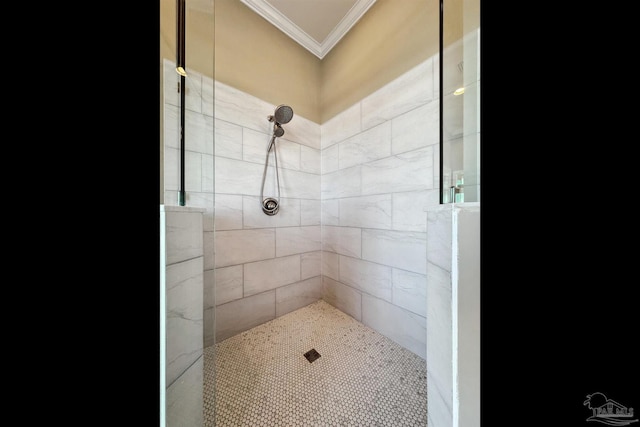 bathroom featuring a tile shower and ornamental molding