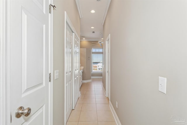 corridor with light tile patterned floors and ornamental molding