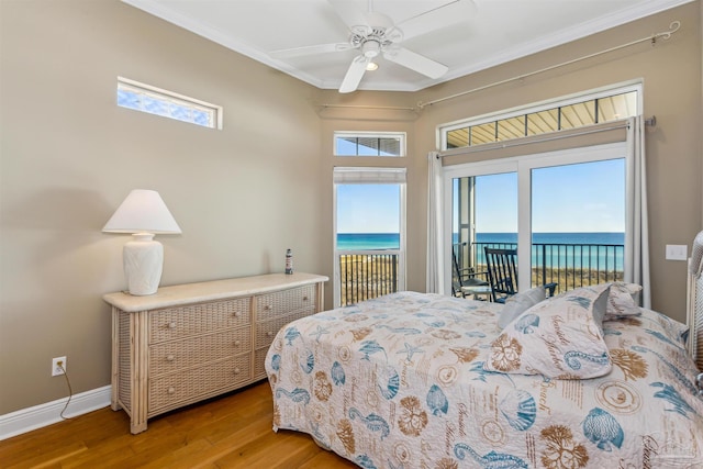 bedroom featuring access to exterior, ceiling fan, a water view, and wood-type flooring