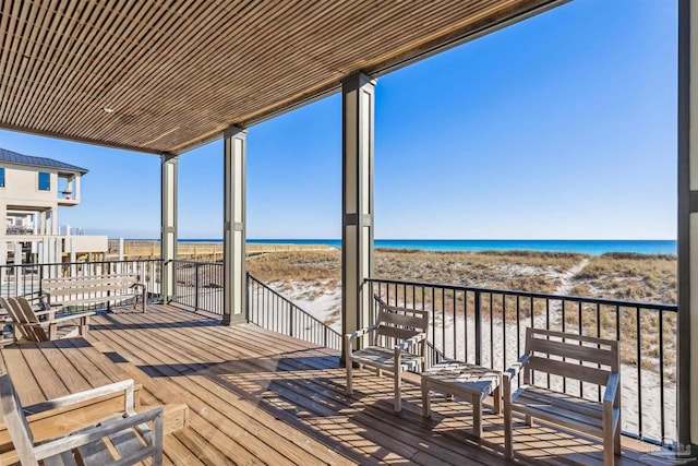 wooden deck with a beach view and a water view