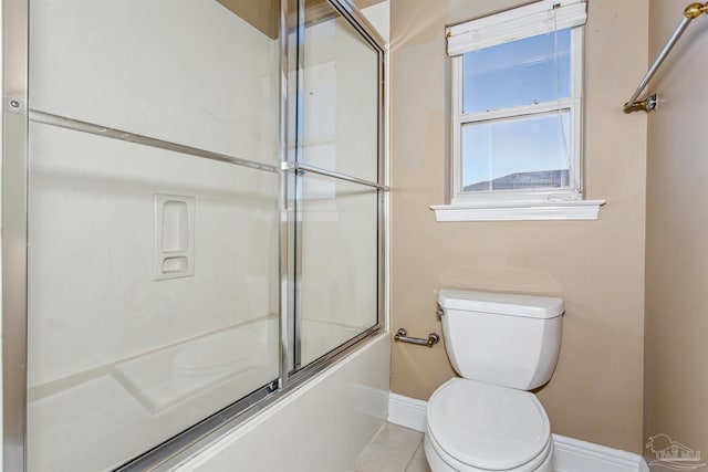 bathroom featuring tile patterned floors, toilet, and combined bath / shower with glass door