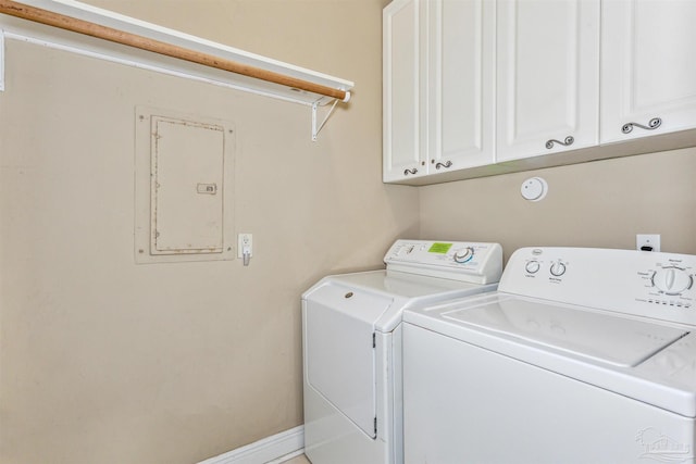 laundry room with cabinets, electric panel, and washing machine and clothes dryer