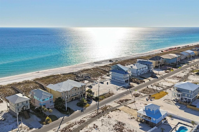 birds eye view of property featuring a water view and a beach view