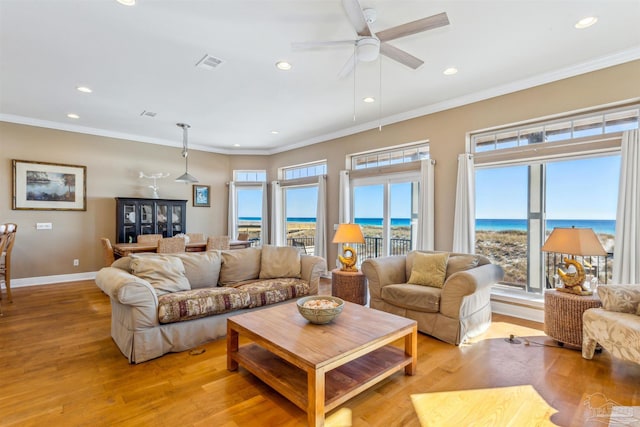 living room featuring a water view, light hardwood / wood-style floors, and ornamental molding