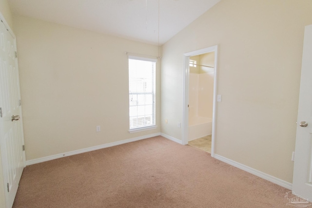 7101 Joy St Unit J5, Pensacola, FL 32504 - unfurnished bedroom with light colored carpet, lofted ceiling, baseboards, and ensuite bath