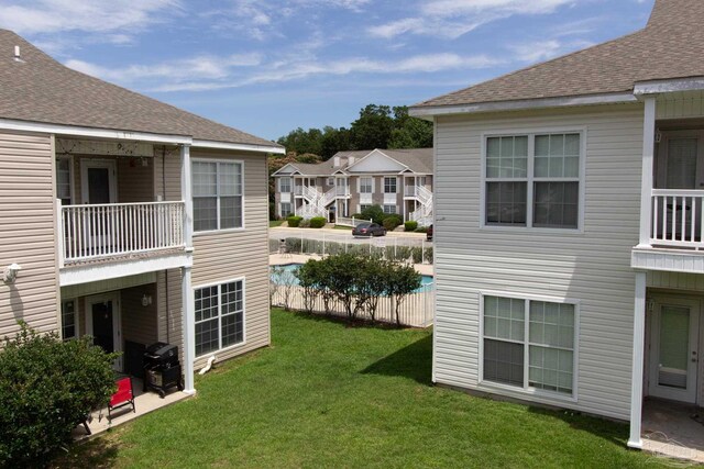 7101 Joy St Unit J5, Pensacola, FL 32504 - view of green lawn with an outdoor pool, a balcony, and a residential view