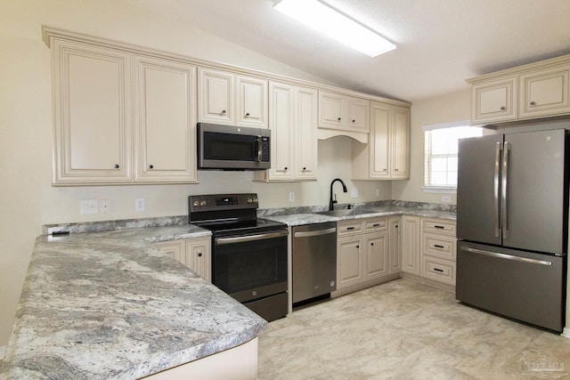 7101 Joy St Unit J5, Pensacola, FL 32504 - kitchen with stainless steel appliances, cream cabinetry, a sink, lofted ceiling, and light stone counters