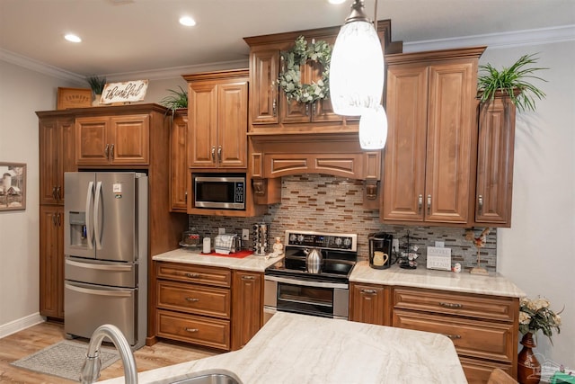 kitchen featuring pendant lighting, sink, crown molding, appliances with stainless steel finishes, and decorative backsplash