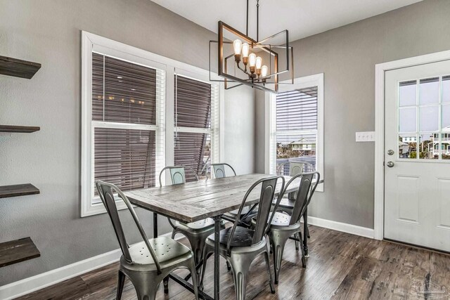 dining space with dark wood-type flooring and a notable chandelier
