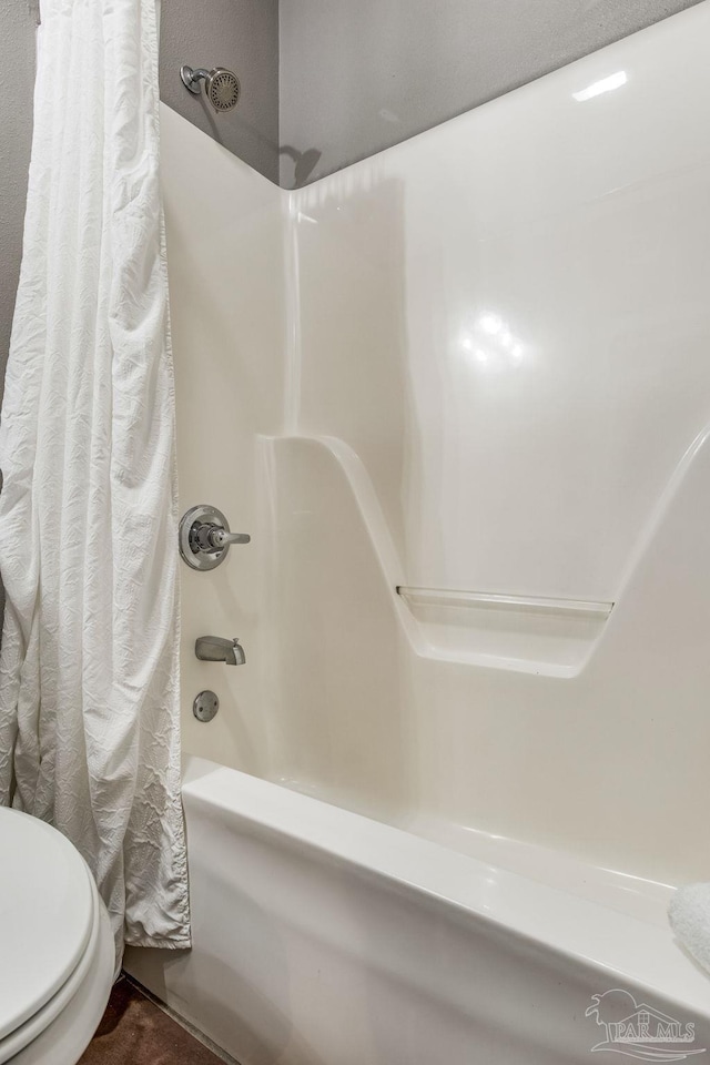 bathroom with shower / tub combo with curtain and toilet