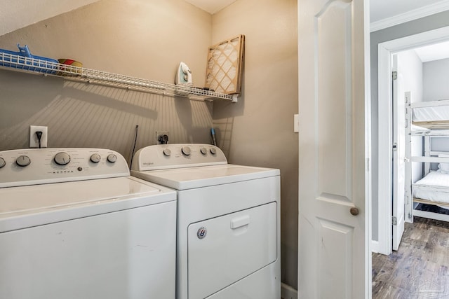 clothes washing area with ornamental molding, light hardwood / wood-style floors, and washing machine and dryer