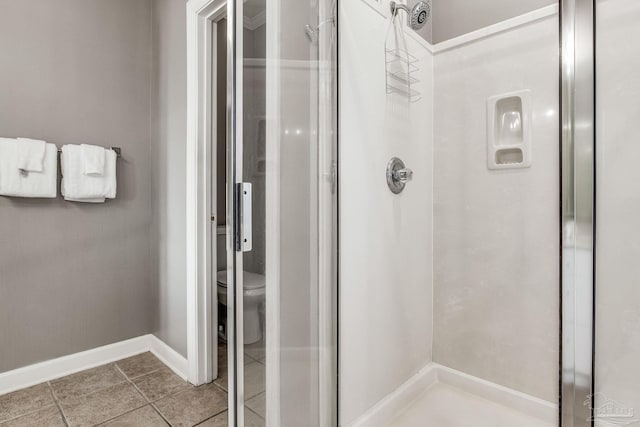 bathroom featuring tile patterned flooring, walk in shower, and toilet