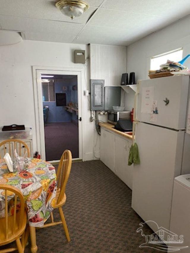 kitchen featuring a drop ceiling, carpet, and white refrigerator