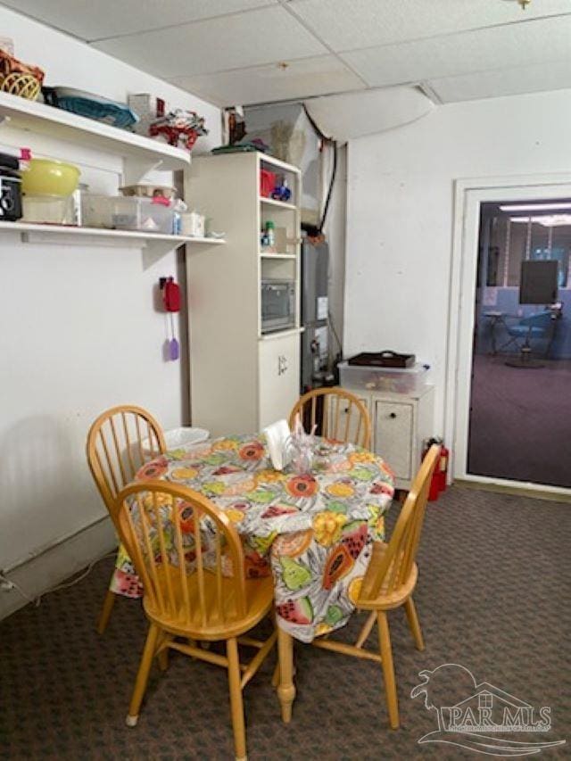 carpeted dining room with a drop ceiling