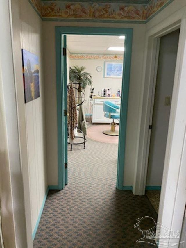corridor featuring baseboards and carpet floors