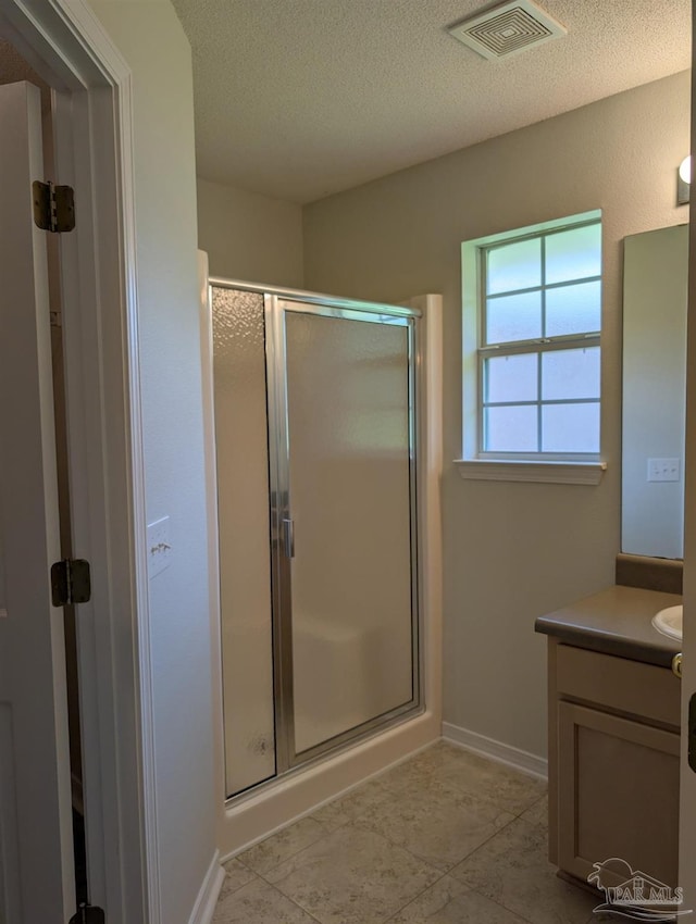 2441 Pine Forest Rd, Pensacola, FL 32533 - bathroom with a stall shower, vanity, a textured ceiling, and baseboards