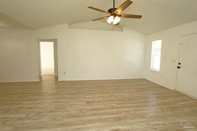 spare room featuring ceiling fan, lofted ceiling, and light wood-type flooring