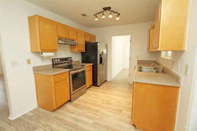 kitchen with stainless steel appliances, light hardwood / wood-style floors, and sink