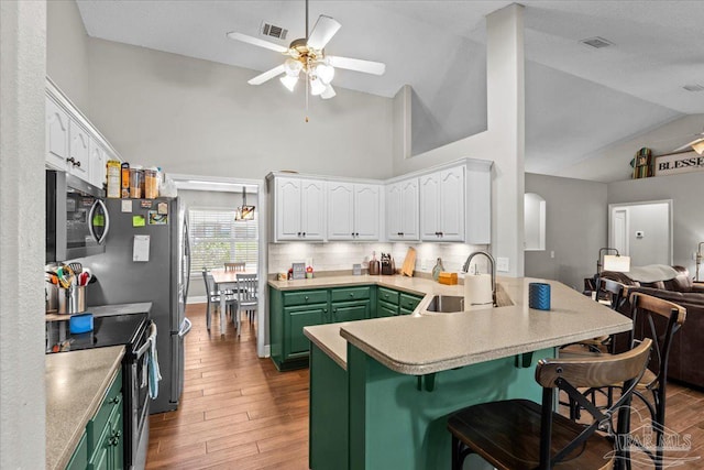 2863 Wallace Lake Rd, Pace, FL 32571 - kitchen featuring visible vents, a peninsula, a sink, appliances with stainless steel finishes, and green cabinets
