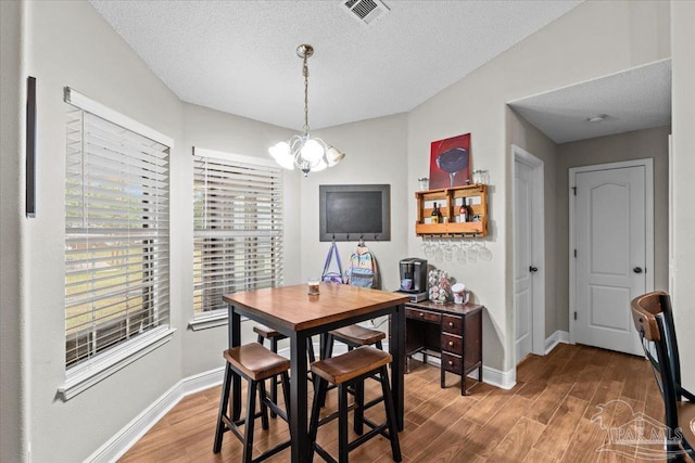 2863 Wallace Lake Rd, Pace, FL 32571 - dining area featuring a notable chandelier, a healthy amount of sunlight, and wood finished floors