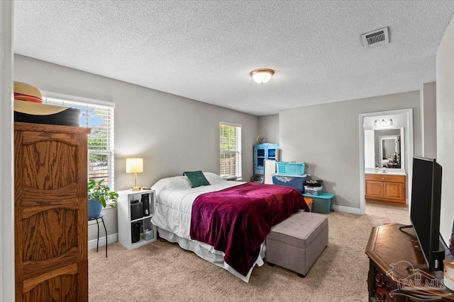2863 Wallace Lake Rd, Pace, FL 32571 - bedroom with light carpet, a textured ceiling, baseboards, ensuite bathroom, and visible vents