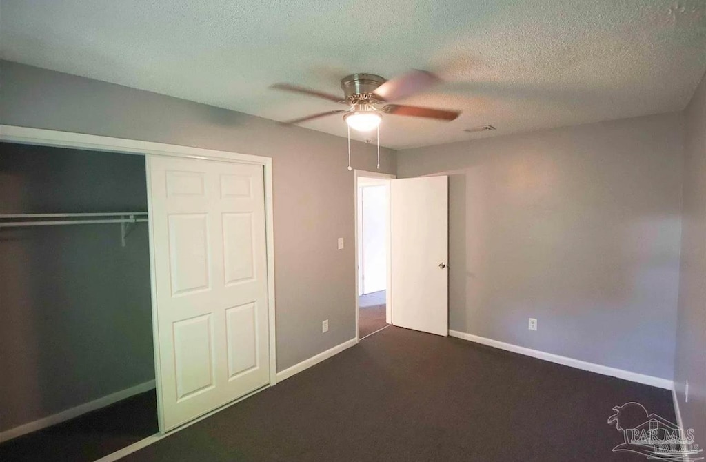 unfurnished bedroom featuring a closet, ceiling fan, carpet, and a textured ceiling