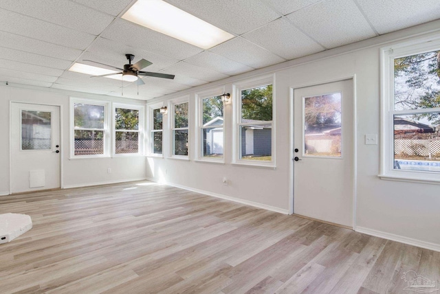 unfurnished sunroom with a drop ceiling and a ceiling fan