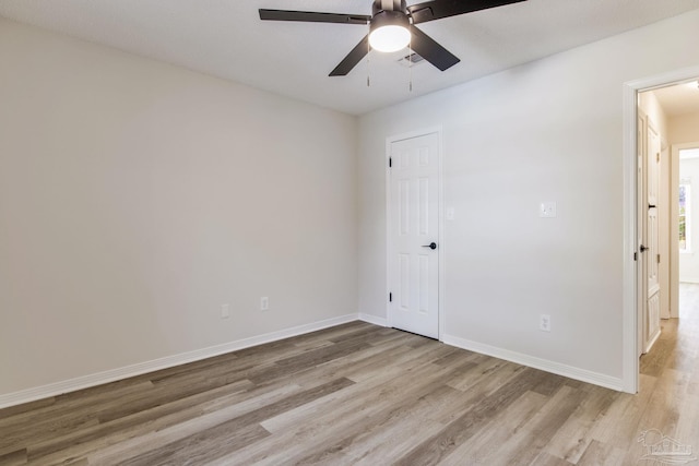 spare room with light wood-style floors, visible vents, baseboards, and a ceiling fan