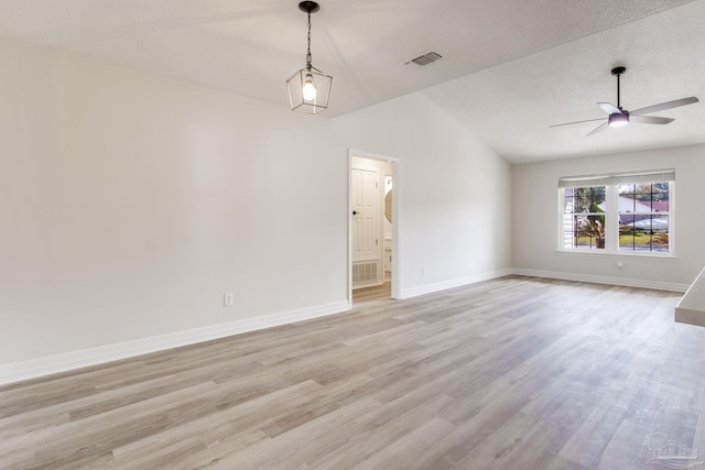 unfurnished room featuring light wood-type flooring, visible vents, lofted ceiling, and baseboards