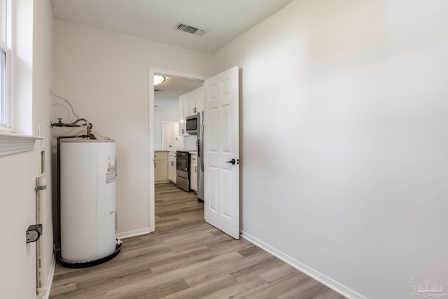 interior space with water heater and visible vents