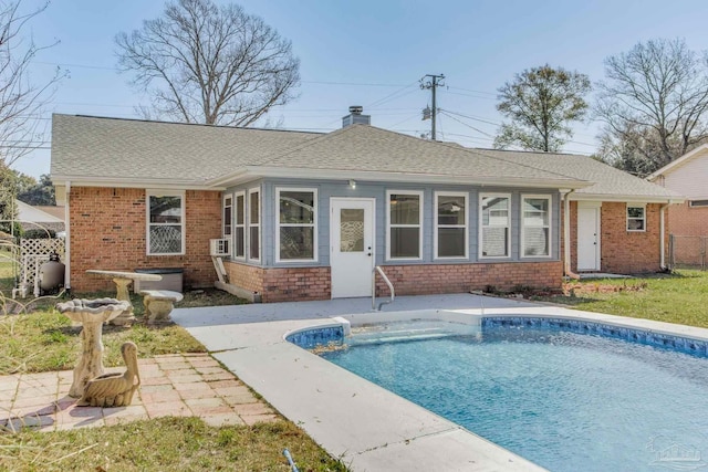 back of house featuring roof with shingles, an outdoor pool, and a chimney