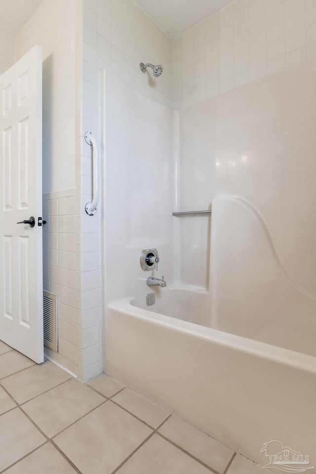 bathroom with visible vents, shower / tub combination, tile patterned flooring, and tile walls