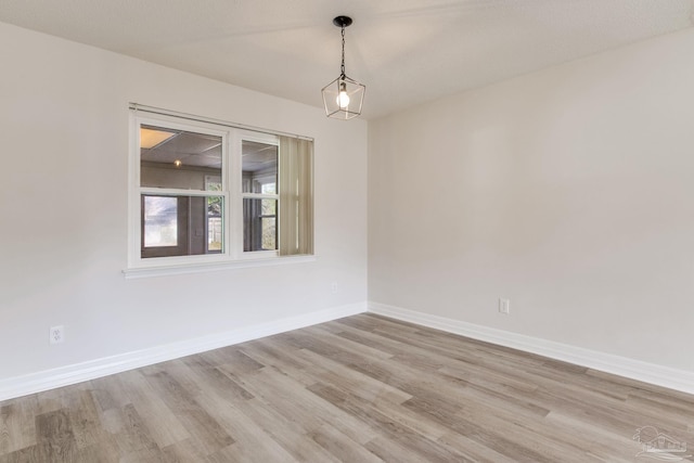 spare room with light wood-type flooring and baseboards