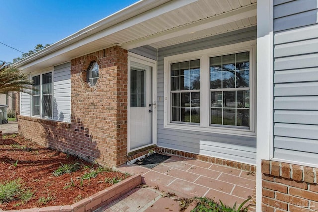 property entrance featuring brick siding