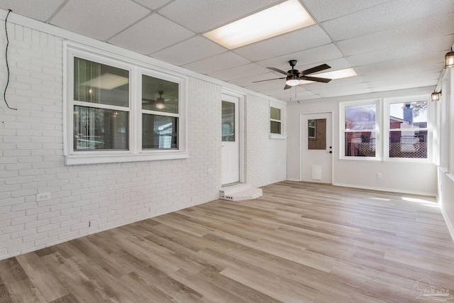 unfurnished sunroom featuring ceiling fan and a paneled ceiling