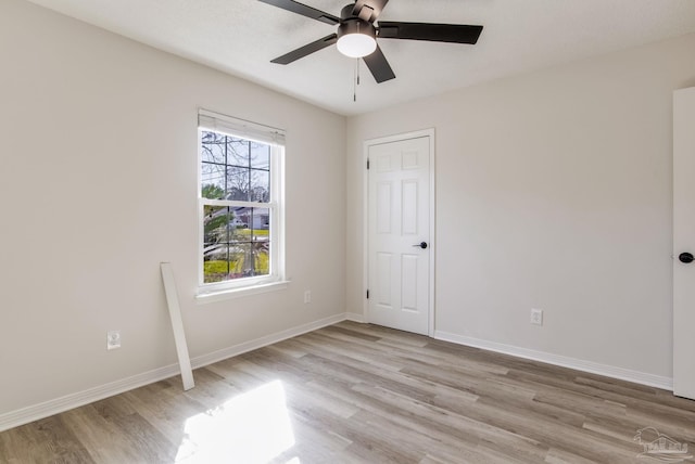 unfurnished bedroom with light wood-style floors, ceiling fan, and baseboards