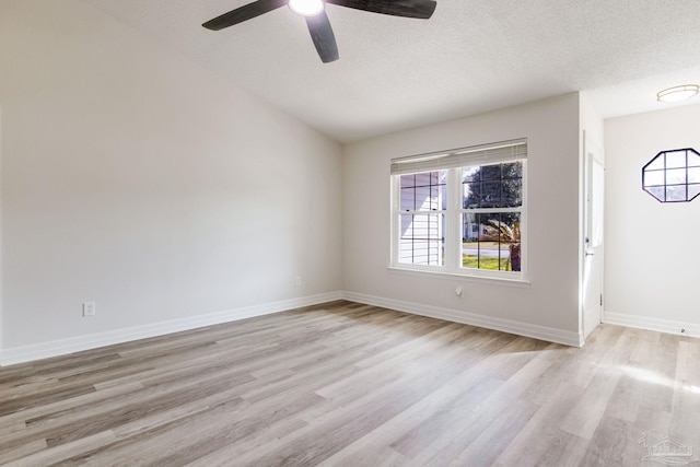 spare room featuring baseboards, a textured ceiling, a ceiling fan, and light wood-style floors