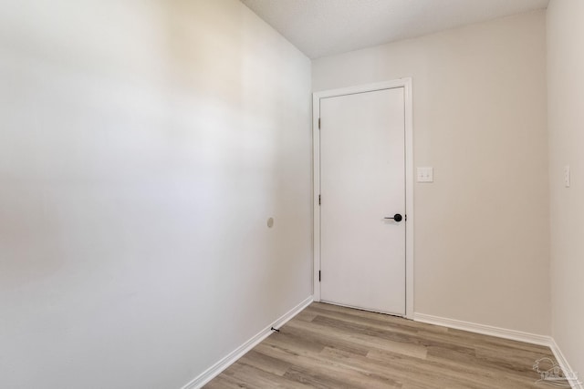 empty room featuring light wood-style flooring and baseboards