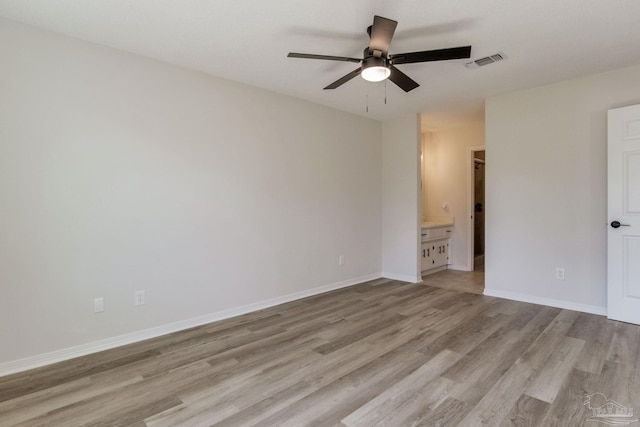 spare room featuring baseboards, a ceiling fan, visible vents, and light wood-style floors